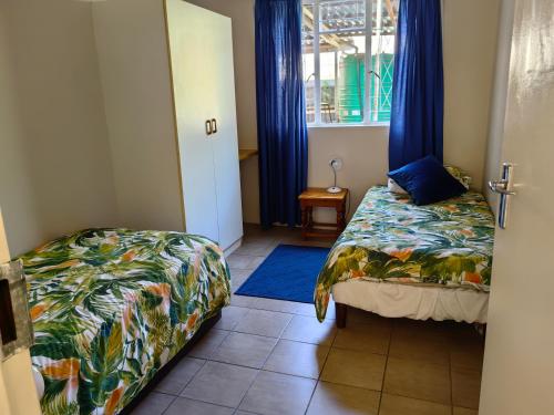 Habitación pequeña con cama y ventana en Thandanani Serene place, en Pietermaritzburg