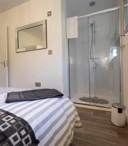 a bedroom with a bed and a glass shower at 35 Quaker Lane in Darlington