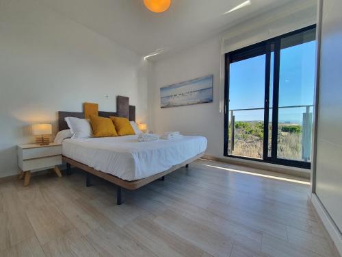 een slaapkamer met een groot bed en een groot raam bij AL048 Pinada Beach IV La Mata in La Mata
