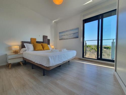 ein Schlafzimmer mit einem großen Bett und einem großen Fenster in der Unterkunft AL048 Pinada Beach IV La Mata in La Mata