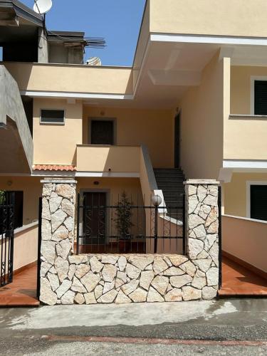 une maison avec un mur en pierre et un balcon dans l'établissement L'Alba, à Tropea