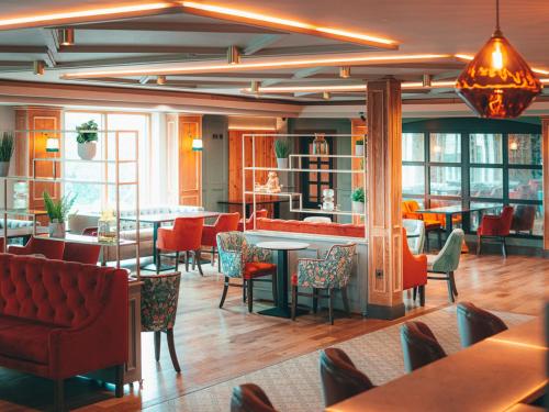 ein Restaurant mit roten Stühlen und Tischen und eine Bar in der Unterkunft Seagoe Hotel in Portadown