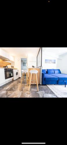 un salon avec un canapé bleu et une table dans l'établissement Studio charmant, à Nice