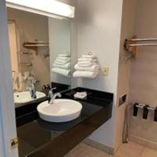 a bathroom with a sink and a mirror and towels at Motel 6-Van Horn, TX in Van Horn