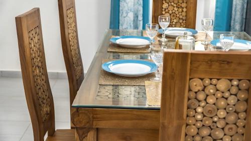 a dining table with blue plates and glasses on it at Garuda Villa in Trou aux Biches