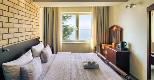 a hotel room with a bed with a window at Royal View Villa in Ohrid