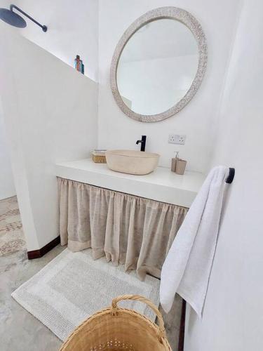 a bathroom with a sink and a mirror on a counter at AO Cottage in Petite Case Noyale
