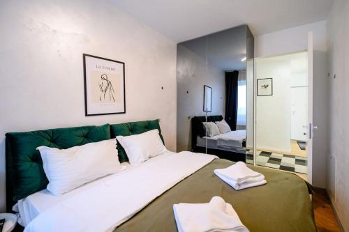 a bedroom with a large bed with white and green at Northern Horizon in Voluntari