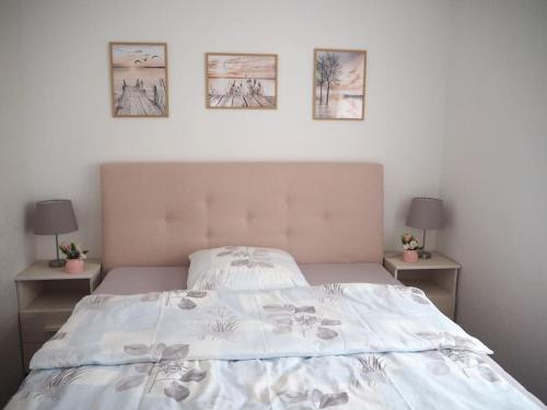 a bedroom with a bed with three pictures on the wall at Ferienwohnung Romantica in Felsberg