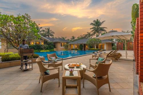 a man playing the piano on the patio of a resort at StayVista at Amara Villa Luxury Collection with Private Pool & Gazebo in Alibaug