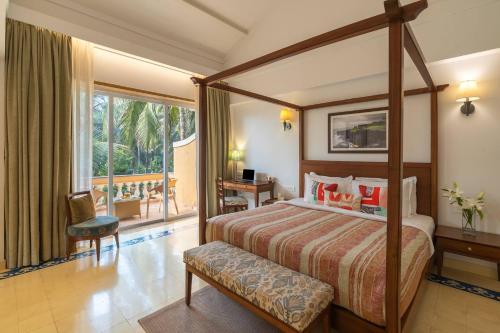 a bedroom with a canopy bed and a balcony at StayVista at Amara Villa Luxury Collection with Private Pool & Gazebo in Alibaug