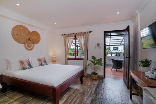 um quarto com uma cama grande e uma televisão em River Retreat Boutique Hotel em Siem Reap