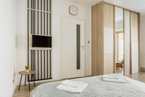 a bedroom with a bed and a clock on a wall at BALANCE apartments in Znojmo