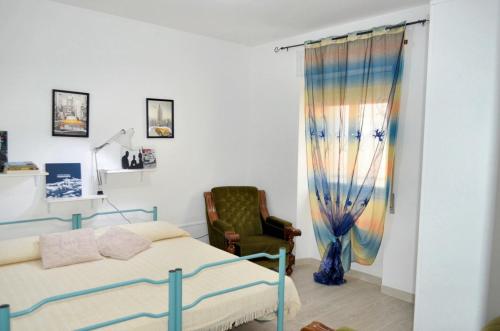Loceri的住宿－One bedroom apartement with city view at Loceri，一间卧室配有一张床和一把椅子