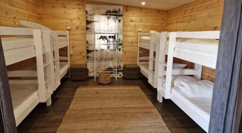 um quarto com beliches brancos num camarote em Kodikas mökki lähellä luontoa Nurmijärven Perttulassa em Nurmijärvi