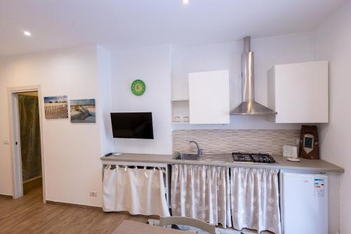 a kitchen with white cabinets and a counter top at A Casa di Amici Apartment in Giardini Naxos