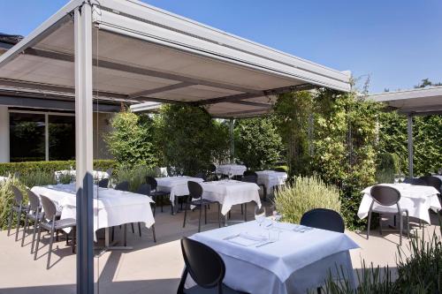 a restaurant with white tables and chairs under a canopy at Locanda La Gazzella in Maranello