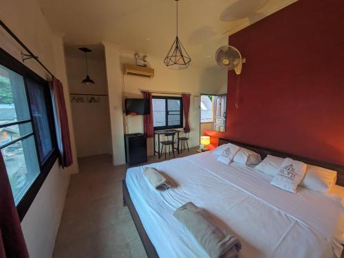 1 dormitorio con 1 cama blanca grande y pared roja en Goodtime Utopia Guesthouse, en Ko Tao