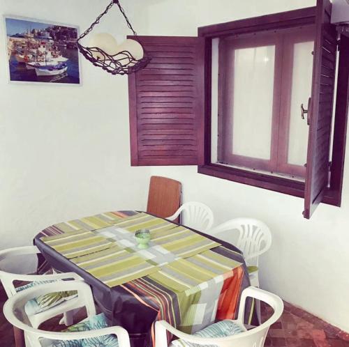 un tavolo da pranzo con sedie e una finestra di 2 bedrooms apartement at Fnideq 10 m away from the beach with furnished garden a Fnidek