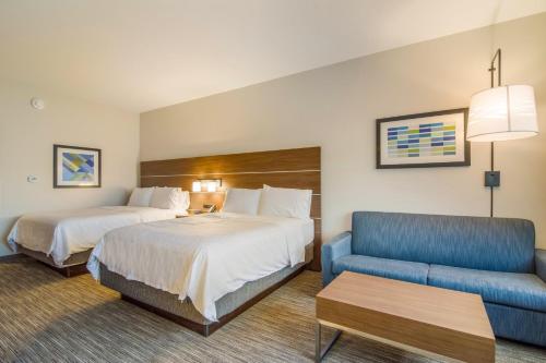 ein Hotelzimmer mit zwei Betten und einer Couch in der Unterkunft Holiday Inn Express & Suites - Asheboro by IHG in Asheboro