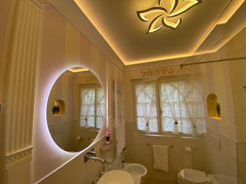 ein Badezimmer mit einem Waschbecken, einem WC und einem Spiegel in der Unterkunft Villa Poggio Ulivo Pool-Apartments in Rivoli Veronese