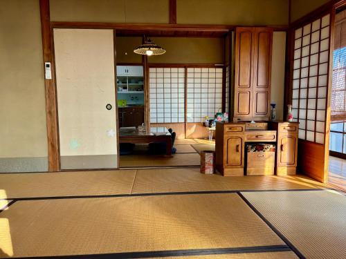 uma cozinha com uma porta aberta para uma sala de estar em 城跡石垣上の絶景古民家宿 鞆城茶屋庵 em Tomo