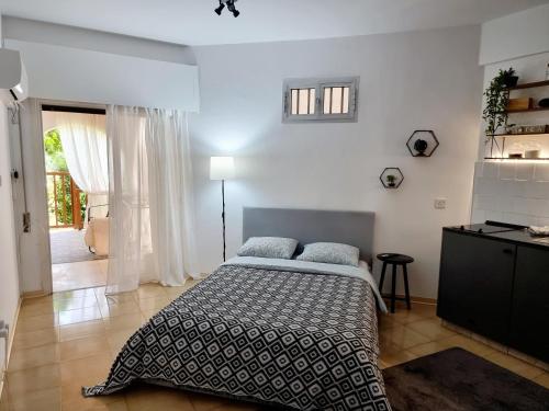 a bedroom with a bed and a table and a window at Paradise Gardens, sweet Apartment in Limassol