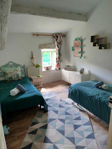 une chambre avec deux lits et un tapis dans l'établissement Domaine du Moulin de Cors, à La Roque-sur-Cèze