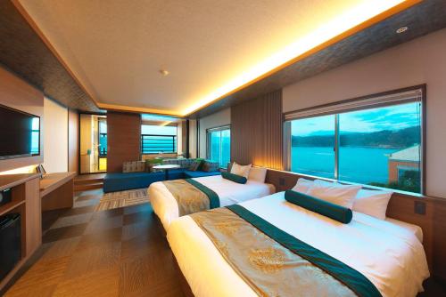 a hotel room with two beds and a large window at Senoumi in Higashiizu