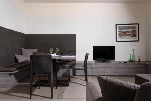 a living room with a table with chairs and a television at Locanda La Gazzella in Maranello