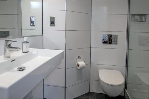 a white bathroom with a toilet and a sink at Best Western Appleby Park Hotel in Tamworth