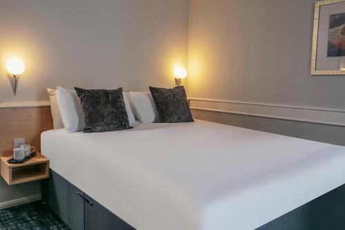 a large white bed in a room with two lamps at Best Western Appleby Park Hotel in Tamworth