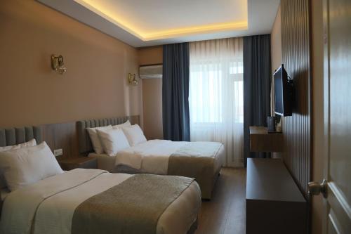 a hotel room with two beds and a television at Otel 57 in Sinop
