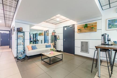 ein Wohnzimmer mit einem Sofa und einem Tisch in der Unterkunft Appart'City Confort Angers in Angers