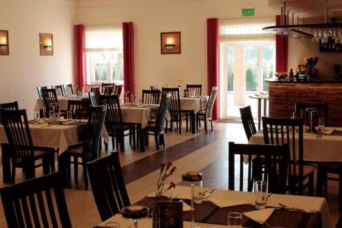 a dining room with tables and chairs in a restaurant at Hotel Marusza in Grudziądz