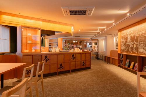 a restaurant with tables and chairs and a counter at Matsumoto Tourist Hotel in Matsumoto