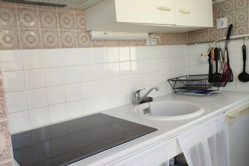 une cuisine avec un évier et un plan de travail dans l'établissement Studio avec terrasse face plage parking, au Barcarès