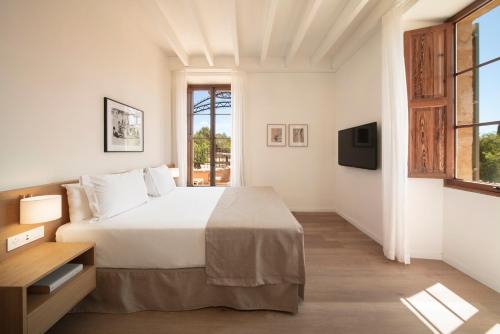 a white bedroom with a bed and a window at Es Figueral Nou Hotel Rural & Spa - Adults Only - Over 12 in Montuiri