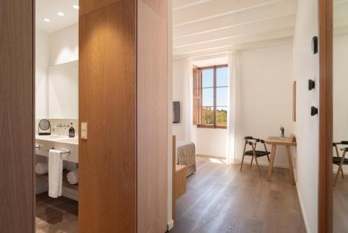 a room with a hallway with a desk and a table at Es Figueral Nou Hotel Rural & Spa - Adults Only - Over 12 in Montuiri