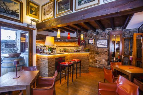 a bar in a restaurant with tables and chairs at Hotel Pilier D'Angle & Wellness in Courmayeur
