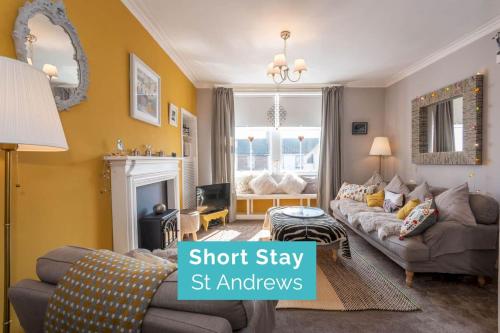 a living room with a couch and a fireplace at McHoppity House - Crail in Crail