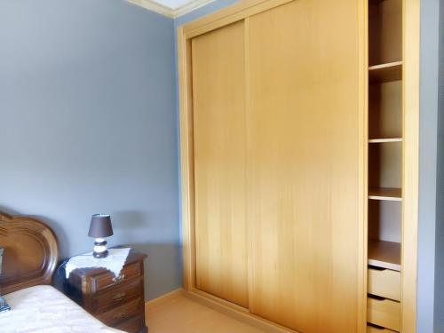 2 bedrooms apartement with enclosed garden and wifi at Urqueira في Urqueira: خزانة في غرفة النوم مع سرير ومصباح