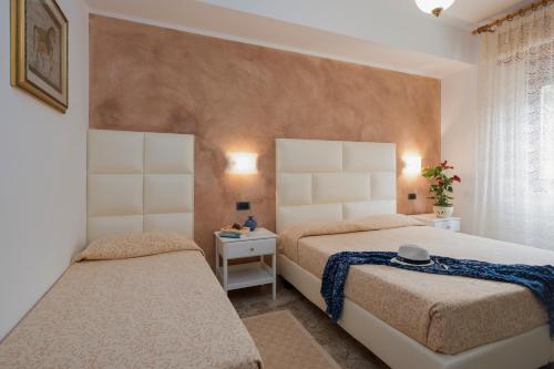 a small bedroom with two beds and a window at Kriss Apartments in Deiva Marina