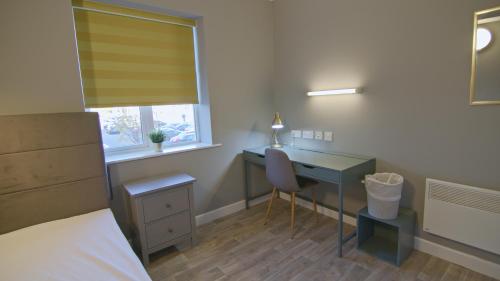 Dormitorio con escritorio, cama, escritorio y silla en Waterford City Campus - Self Catering en Waterford