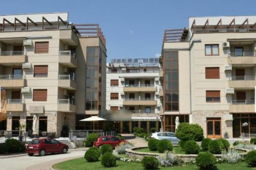 dois edifícios altos com carros estacionados num parque de estacionamento em Apartman Nada de lux em Vrnjačka Banja