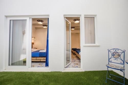 a white house with a chair and a bedroom at Étoiles Guest House in Gioia Tauro