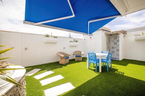 a patio with a table and chairs on grass at Étoiles Guest House in Gioia Tauro