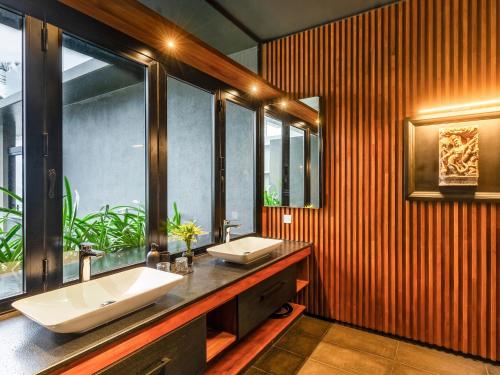 a bathroom with two sinks and a large window at DORMERO Hotel Sri Lanka Hikkaduwa Beach in Hikkaduwa