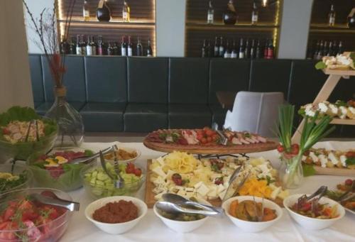 uma mesa com vários tipos diferentes de alimentos em Apartman Nada de lux em Vrnjačka Banja