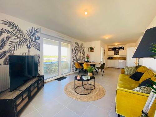 un salon avec un canapé jaune et une télévision dans l'établissement Casa des Ducs, à Angers